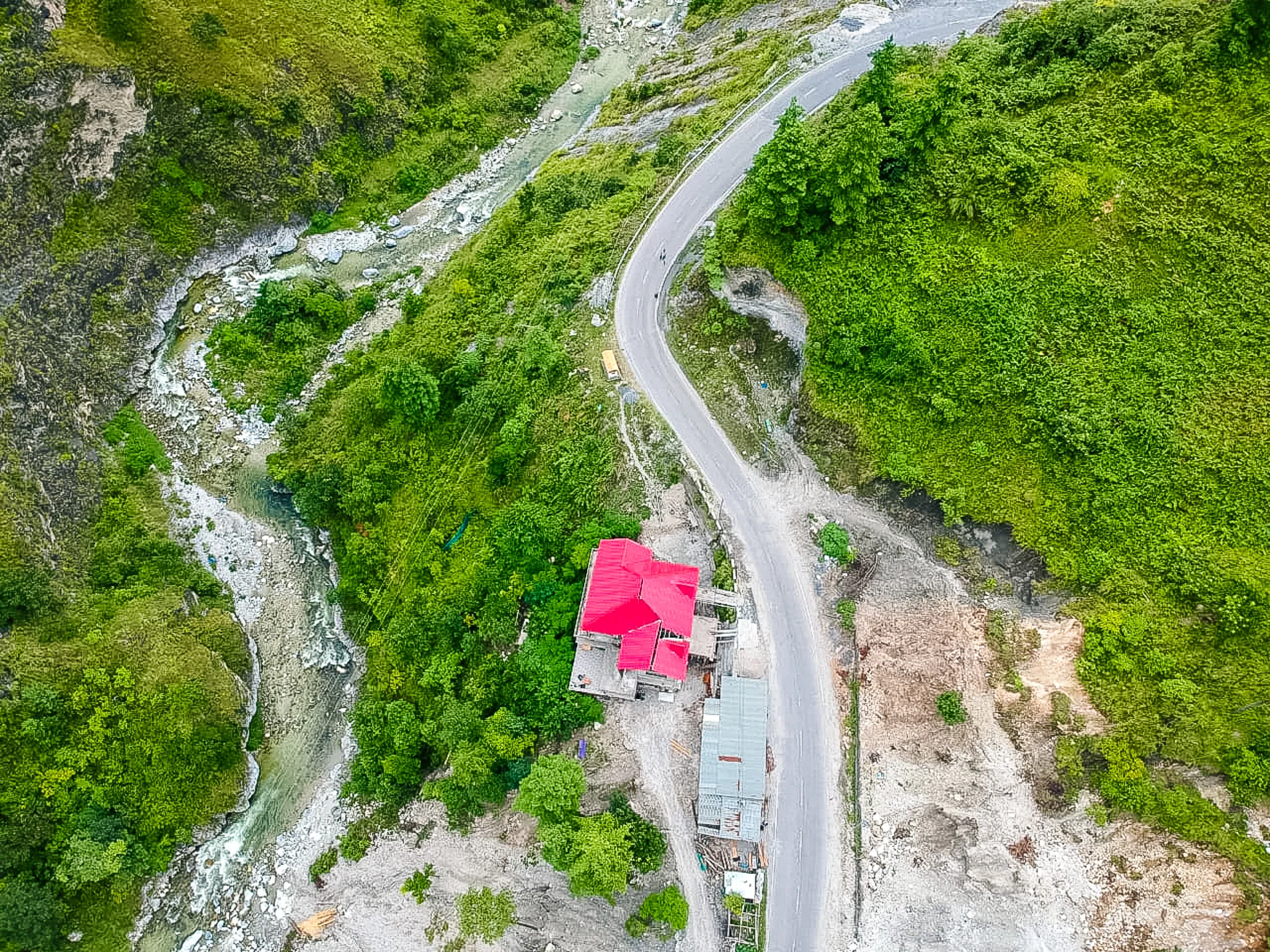 Firong Stay aerial view showing red roof homestay in Rupa valley